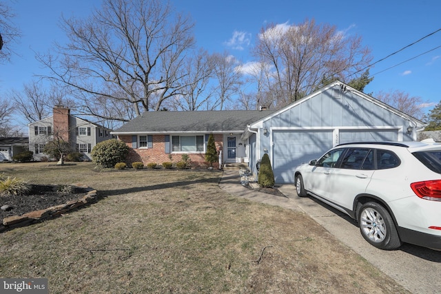 single story home with a garage, a front yard, brick siding, and driveway