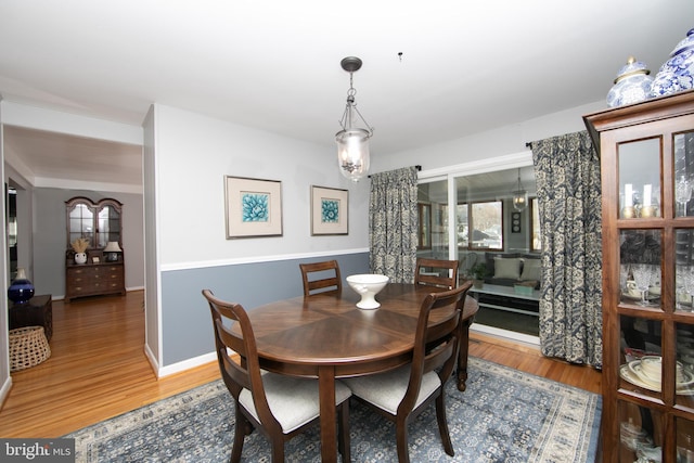 dining room featuring light wood-style flooring and baseboards