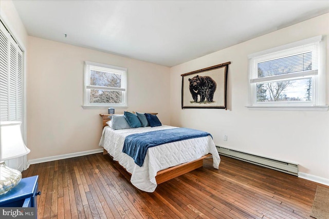 bedroom featuring dark wood-type flooring, multiple windows, a baseboard radiator, and baseboards