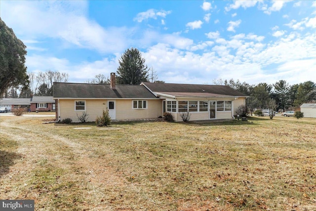 back of property with a yard and a chimney