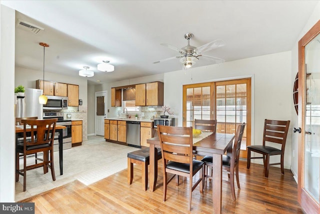 dining room featuring visible vents, ceiling fan, and light wood-style flooring