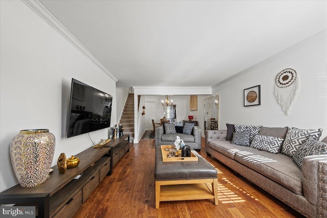 living area with a notable chandelier, crown molding, stairway, and wood finished floors