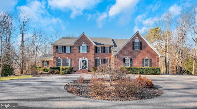 view of front of home featuring driveway and brick siding