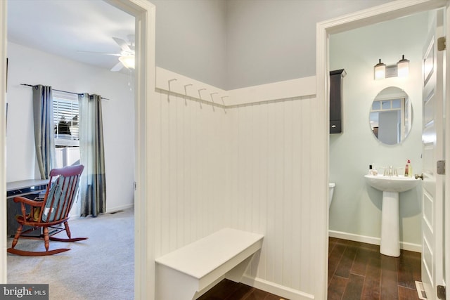 bathroom with toilet, ceiling fan, baseboards, and wood finished floors