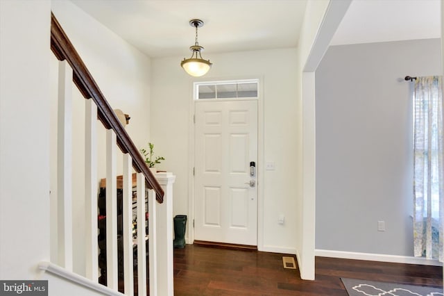 foyer entrance featuring stairs, dark wood finished floors, visible vents, and baseboards