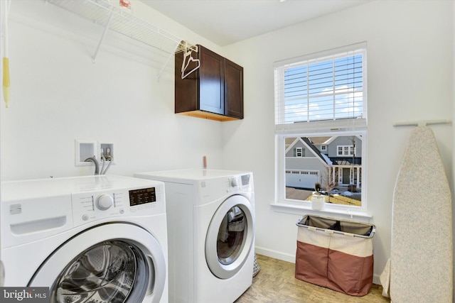 clothes washing area featuring cabinet space, washing machine and dryer, and baseboards