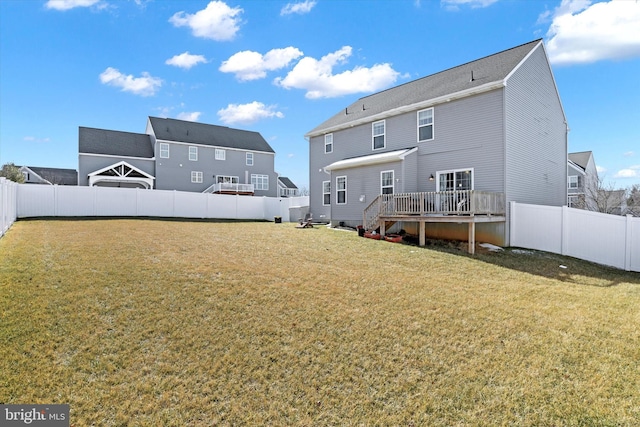 back of property with a fenced backyard, a lawn, and a wooden deck