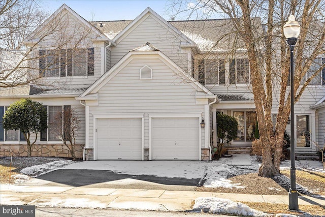 view of front facade with a garage, entry steps, and stone siding