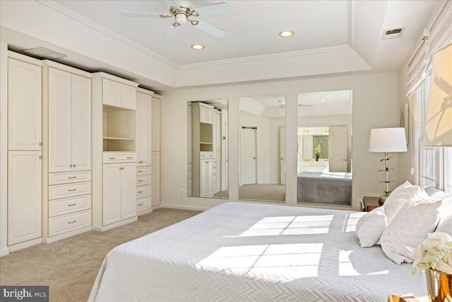 bedroom with recessed lighting, light carpet, visible vents, a tray ceiling, and crown molding