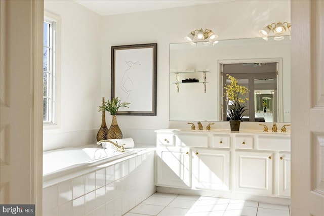 full bathroom featuring double vanity, tile patterned flooring, a tub, and a healthy amount of sunlight