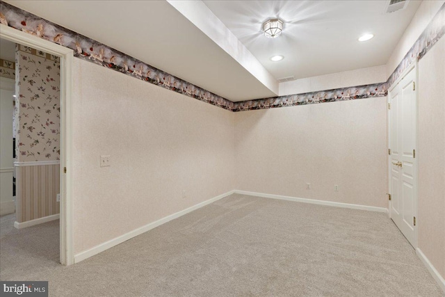 spare room with baseboards, recessed lighting, and light colored carpet