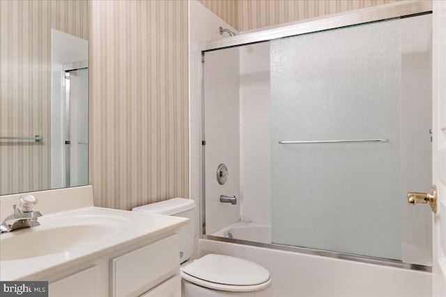 bathroom with toilet, wallpapered walls, enclosed tub / shower combo, and vanity