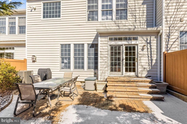 exterior space featuring entry steps, central air condition unit, fence, and outdoor dining area