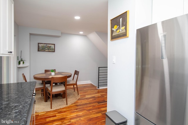 dining room featuring stairs, wood finished floors, and recessed lighting