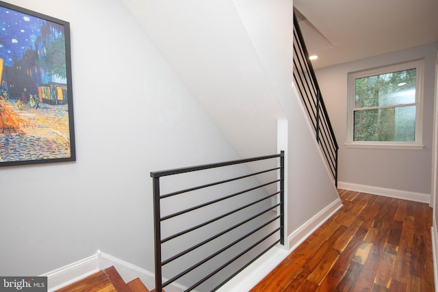 staircase featuring baseboards, wood finished floors, and recessed lighting