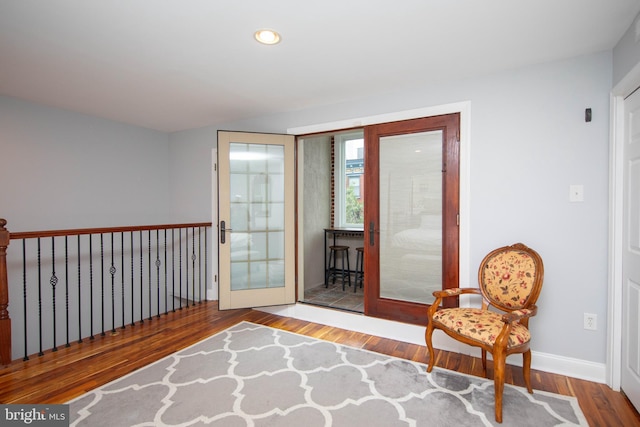 sitting room with baseboards, wood finished floors, and recessed lighting