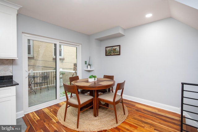 dining space featuring dark wood-style floors, recessed lighting, lofted ceiling, and baseboards