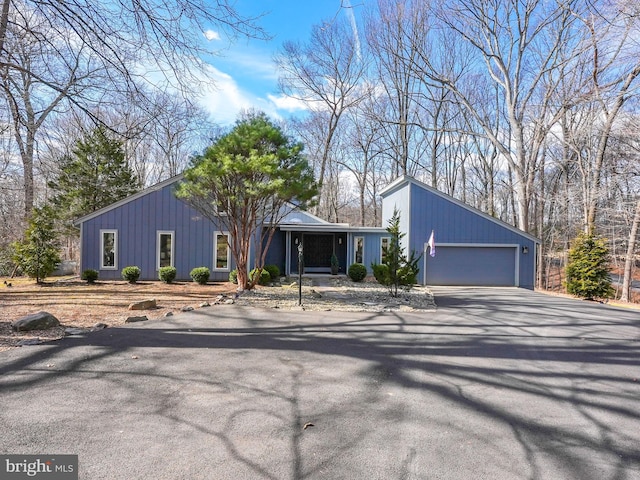 mid-century modern home with aphalt driveway