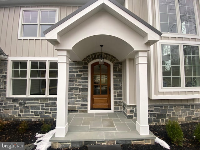 entrance to property with board and batten siding and stone siding