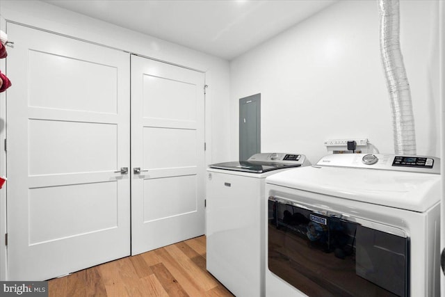 washroom featuring laundry area, light wood-type flooring, independent washer and dryer, and electric panel