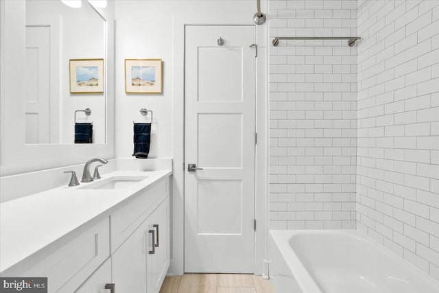 bathroom featuring wood finished floors, vanity, and bathing tub / shower combination