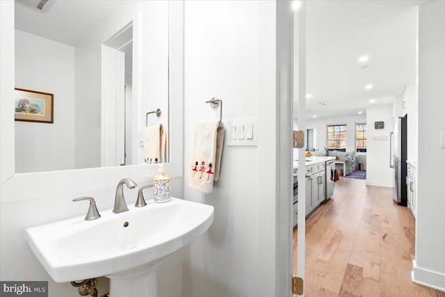 bathroom featuring wood finished floors, a sink, and recessed lighting