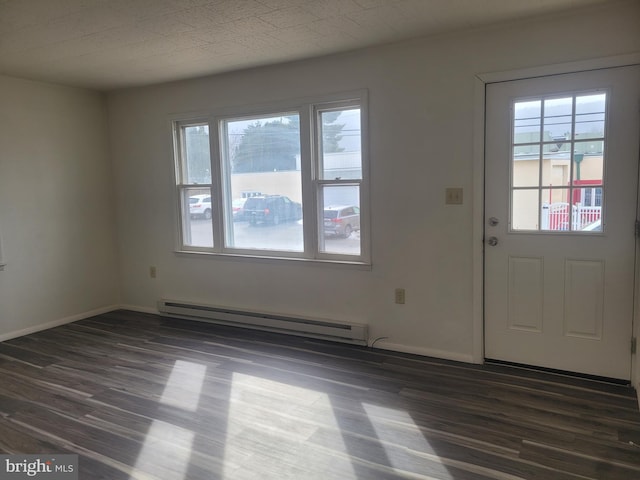 entrance foyer with a baseboard heating unit, dark wood finished floors, and baseboards