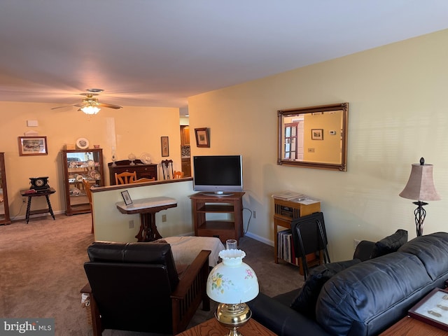 living area with carpet, ceiling fan, and baseboards