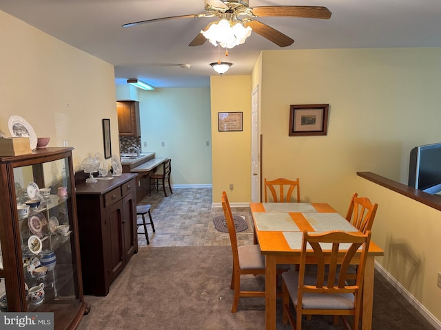 dining area with carpet floors, baseboards, and a ceiling fan