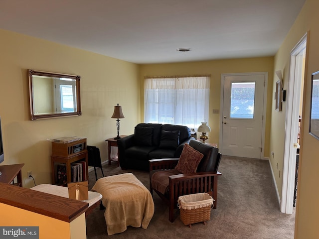 carpeted living room featuring visible vents and baseboards