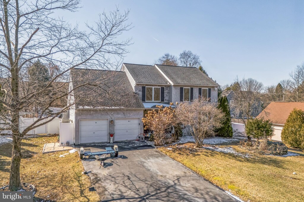view of front of house featuring a garage, a shingled roof, aphalt driveway, fence, and a front yard