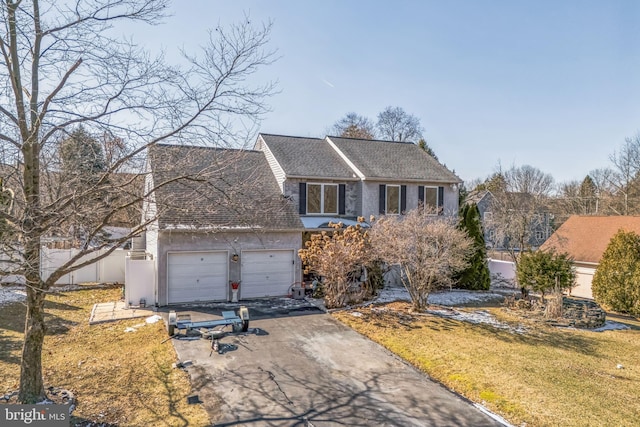 view of front of house featuring a garage, a shingled roof, aphalt driveway, fence, and a front yard