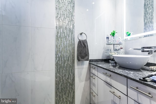 bathroom with decorative backsplash, vanity, and tile walls