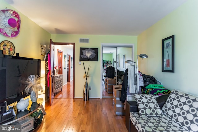 living room with visible vents, baseboards, and wood finished floors