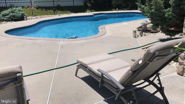 view of swimming pool with a fenced in pool, fence, and a patio