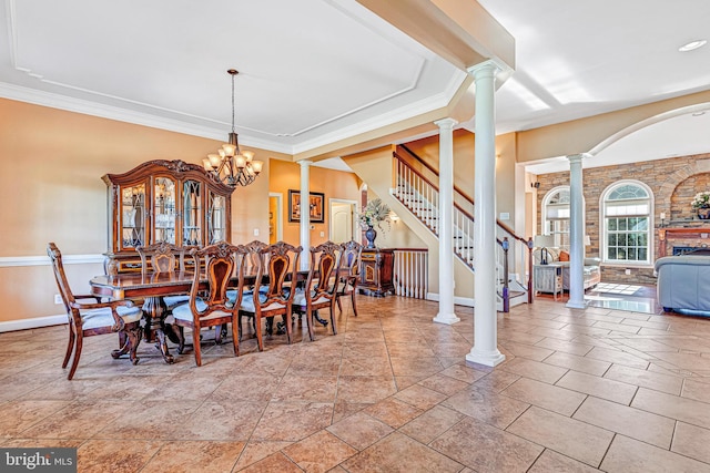 dining room with crown molding, a notable chandelier, ornate columns, baseboards, and stairs