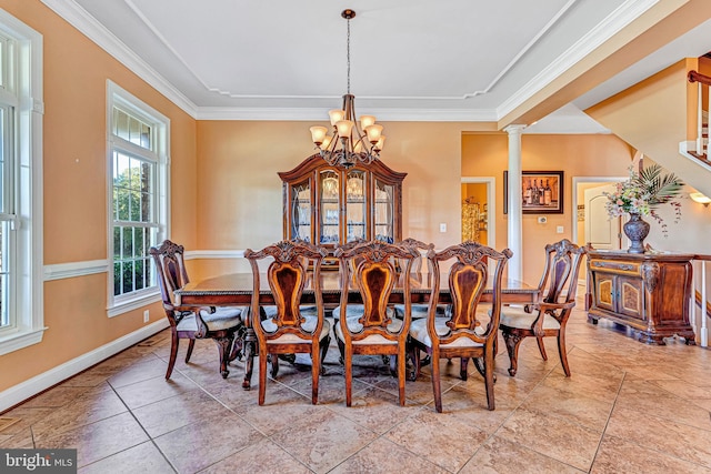 dining room featuring a chandelier, baseboards, ornamental molding, and ornate columns