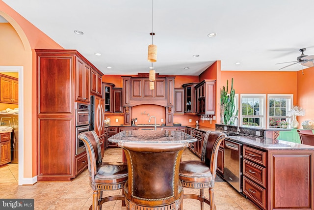 kitchen with a kitchen island with sink, stone counters, glass insert cabinets, and decorative light fixtures