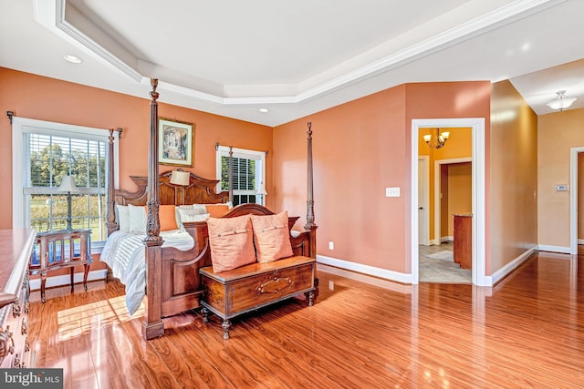 living area with a notable chandelier, recessed lighting, a raised ceiling, light wood-style flooring, and baseboards