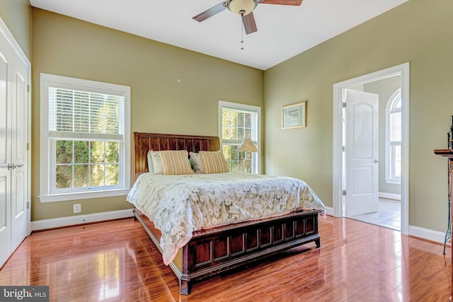 bedroom featuring light wood finished floors, a ceiling fan, and baseboards