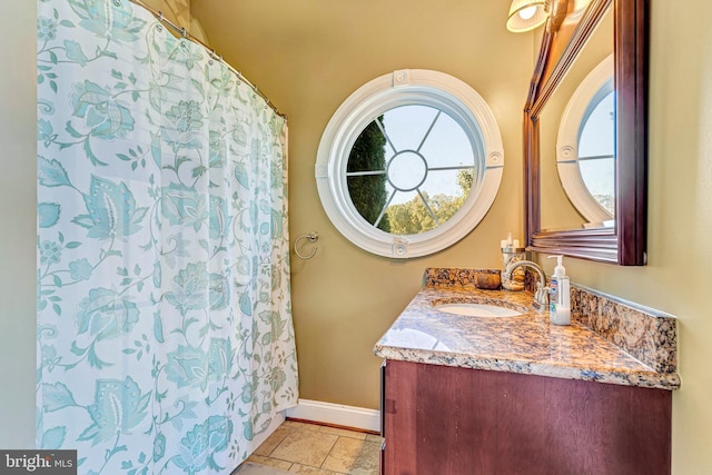 full bathroom with vanity and baseboards