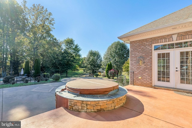 view of patio / terrace featuring french doors, a covered hot tub, and fence