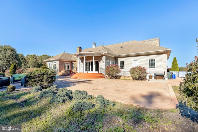 rear view of house with a patio area and a chimney