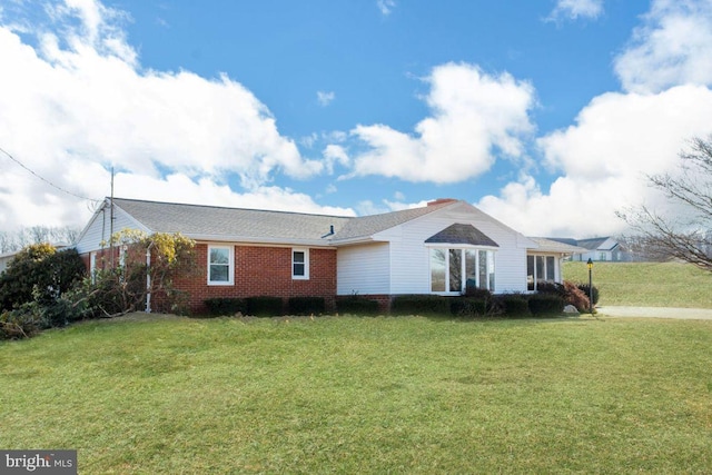 ranch-style house featuring brick siding and a front lawn