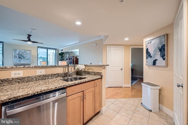 kitchen with light tile patterned floors, light stone counters, a sink, ornamental molding, and stainless steel dishwasher