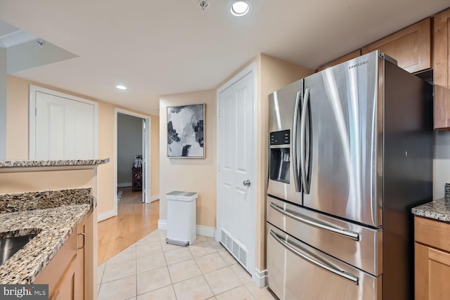 kitchen featuring stainless steel fridge, visible vents, light stone countertops, light tile patterned flooring, and recessed lighting