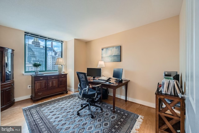 home office featuring light wood-style flooring and baseboards