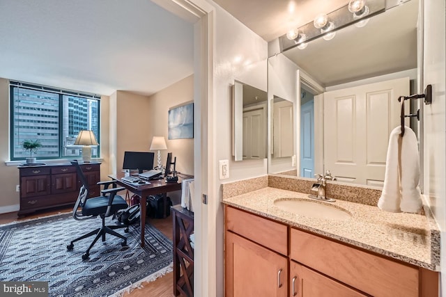 home office with a sink and wood finished floors