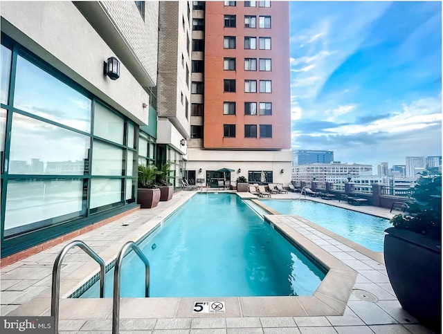 pool featuring a view of city and a patio