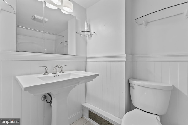 full bathroom with wainscoting, a sink, and toilet